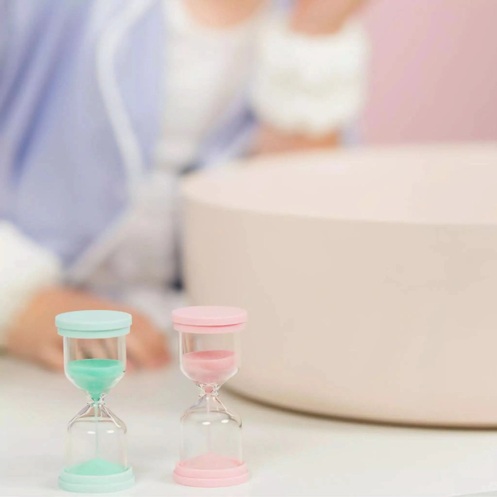 Two Australian made 60 Second Skincare Timers in pink and mint borosilicate glass with sparkly silica, designed for gentle skincare routines for 7 to 14 year olds. Good Skin Habits Start Early.