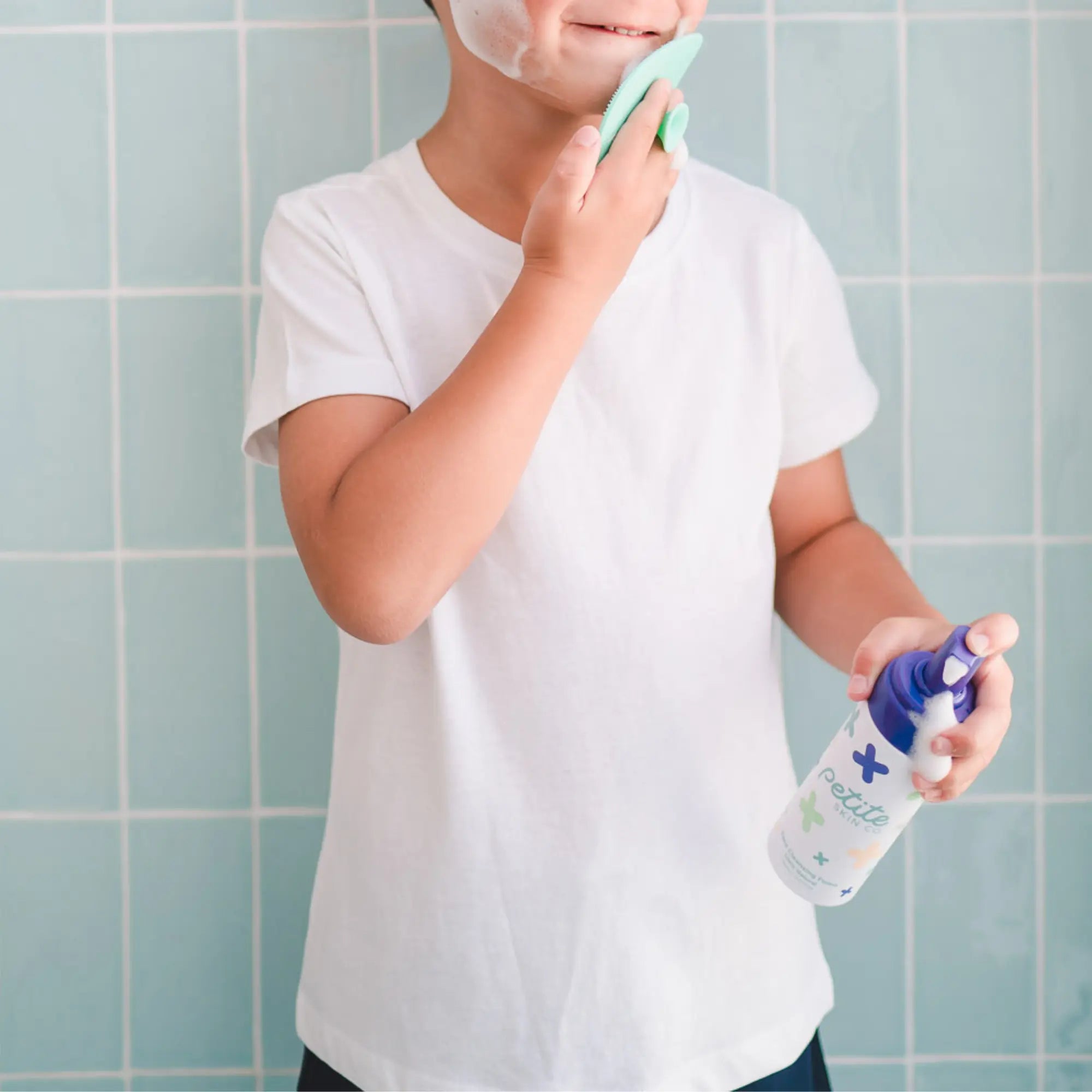 Child using Teardrop Shape Skin Buffers with face cleansing foam in bathroom, demonstrating gentle Australian made skincare for 7 to 14 year olds, promoting good skin habits.
