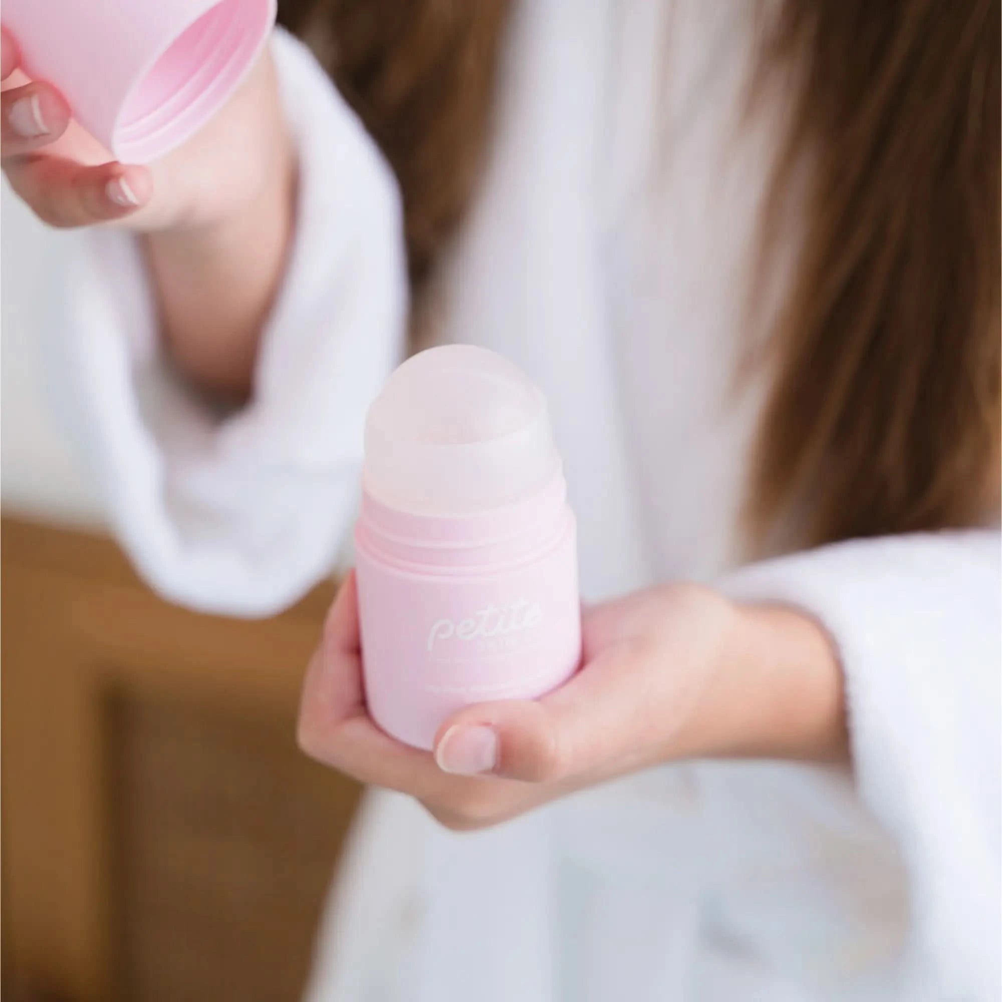 Deodorant in a soft pink container held by a child wearing a white robe, designed for sensitive underarm skin, Australian made, natural, and made for 7 to 14 year olds. Good Skin Habits Start Early.