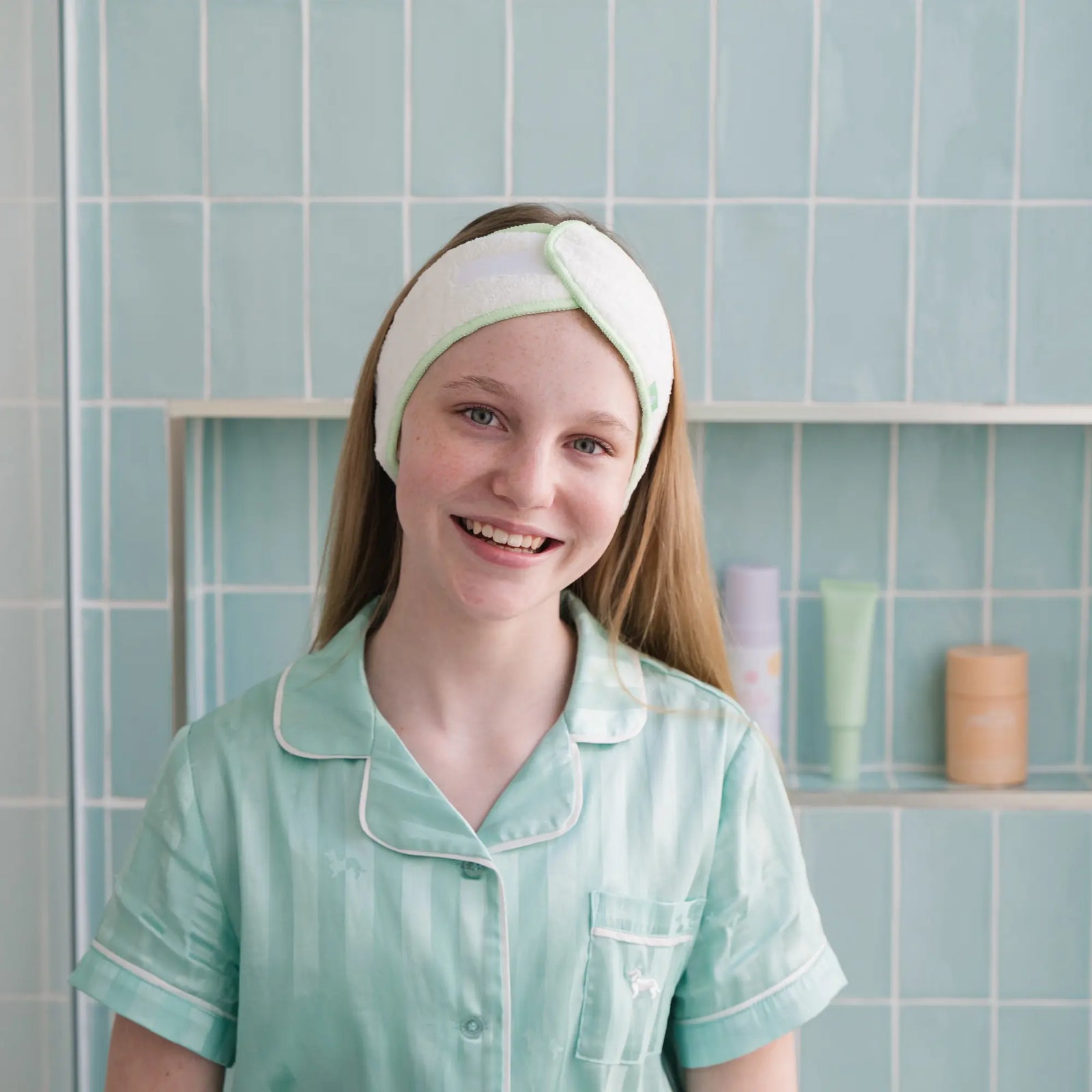 Girl wearing a soft towelling headband with lilac trim, designed to keep hair off the face during skincare routines, made for 7 to 14 year olds and Australian made.