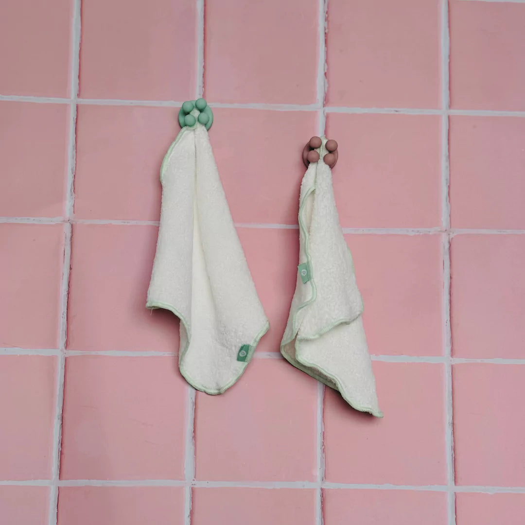 mint and pink Petite Skin Co. bathroom hooks with 2 white face towels with mint trim