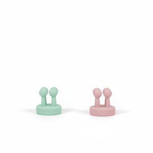 Two Daily Essentials Hook pieces in mint and pink colors made of high-quality water-resistant plastic, featuring strong adhesive backing for easy, damage-free installation. Australian made, supporting good skin habits start early.