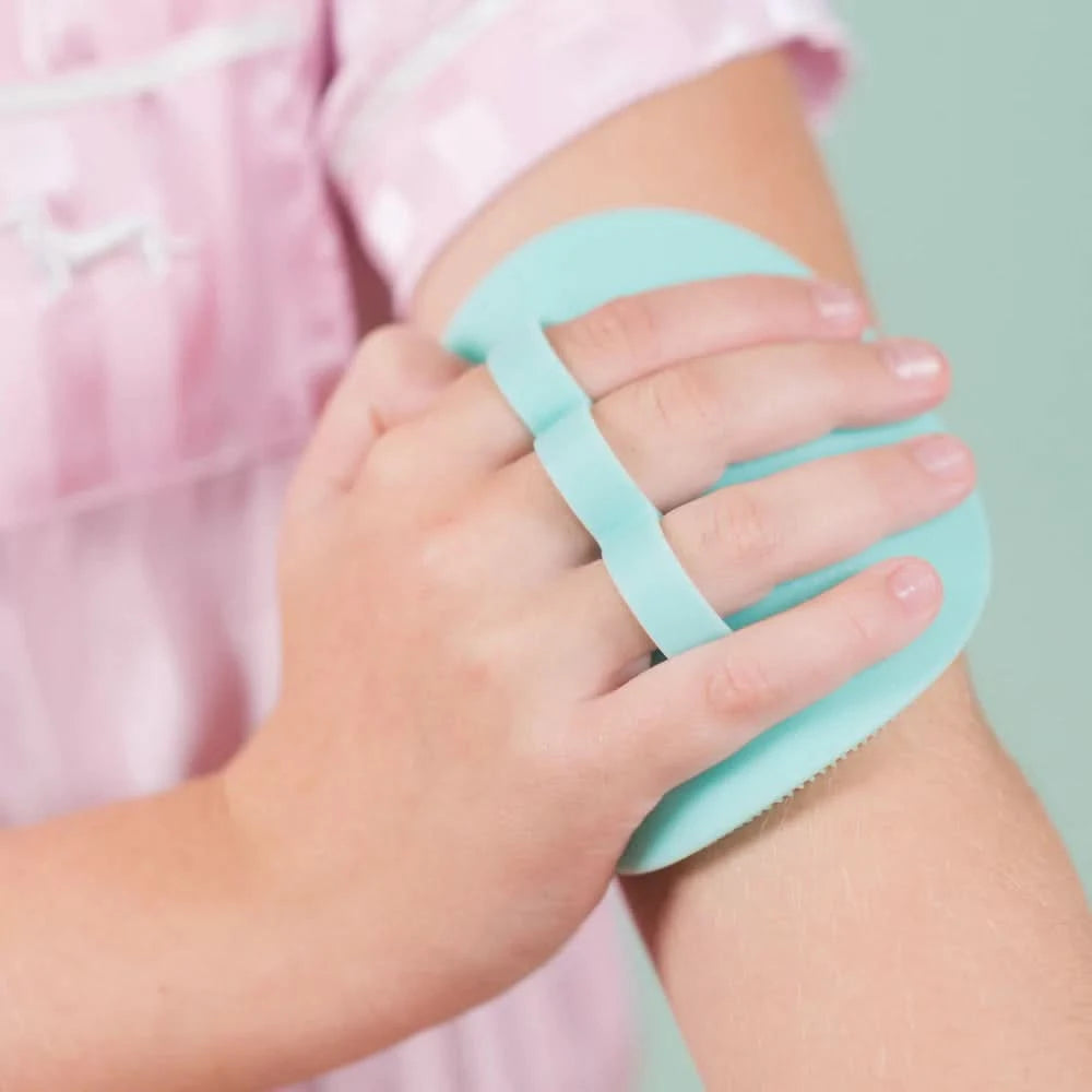 Child using a mint-colored Body Buffer with soft silicone bristles on their arm, designed for gentle Australian made skincare for 7 to 14 year olds. Good Skin Habits Start Early.