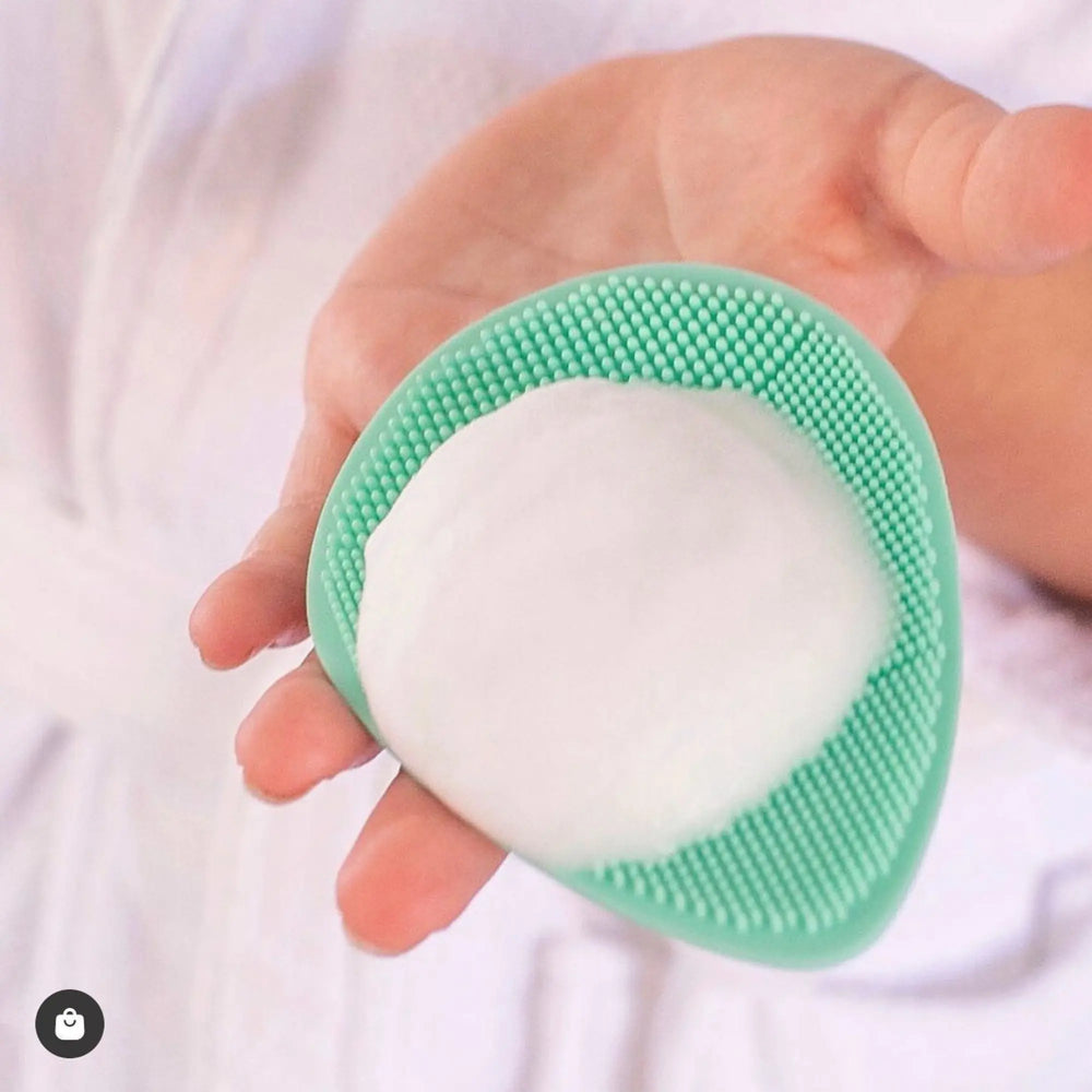 Hand holding a mint green Teardrop Shape Skin Buffers with white foamy face cleansing foam, designed for gentle skincare for 7 to 14 year olds, Australian made, natural, good skin habits start early.