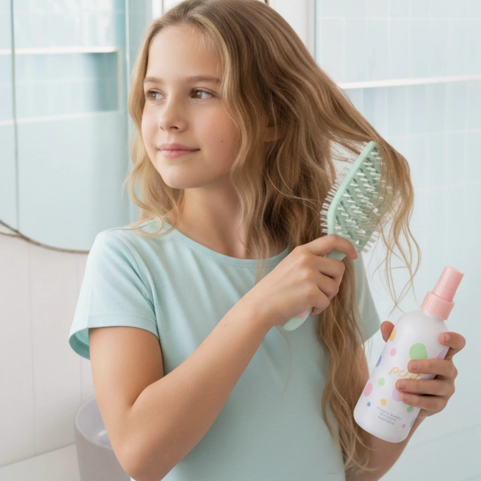 Young girl using the Tangle-Free Duo nourishing detangler spray and dual-bristle brush to gently detangle her hair, promoting good hair care habits early, Australian made.