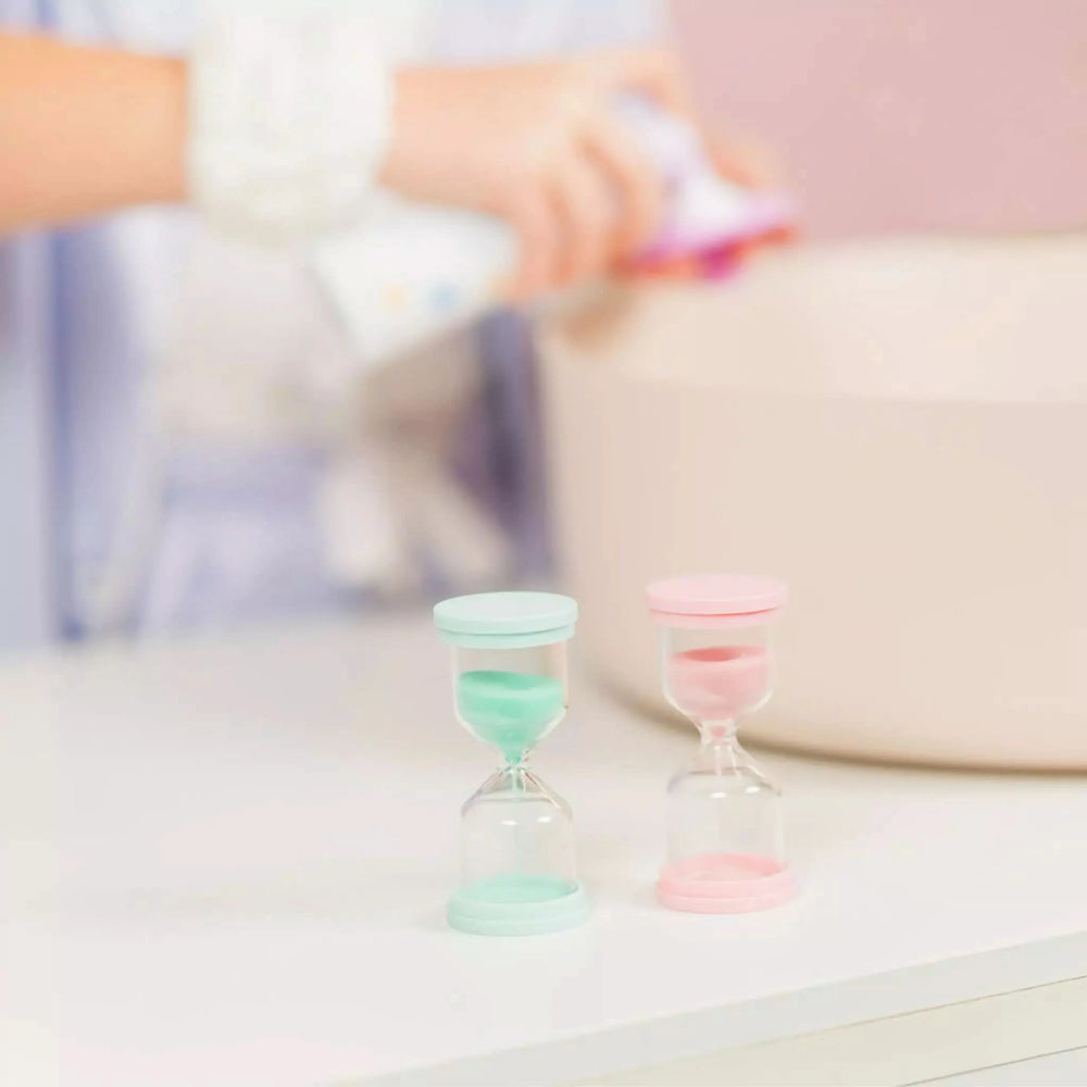 Two 60 Second Skincare Timers in soft pastel green and pink, Australian made from sturdy borosilicate glass, designed for gentle skincare routines for 7 to 14 year olds. Good Skin Habits Start Early.
