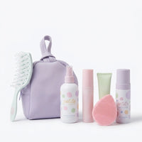 The Sleepover Essentials Kit featuring Australian made, natural skincare products for 7 to 14 year olds, including gentle face cleansing foam, moisturiser, and a pink silicone cleansing brush in a lavender holographic bag. Good Skin Habits Start Early.