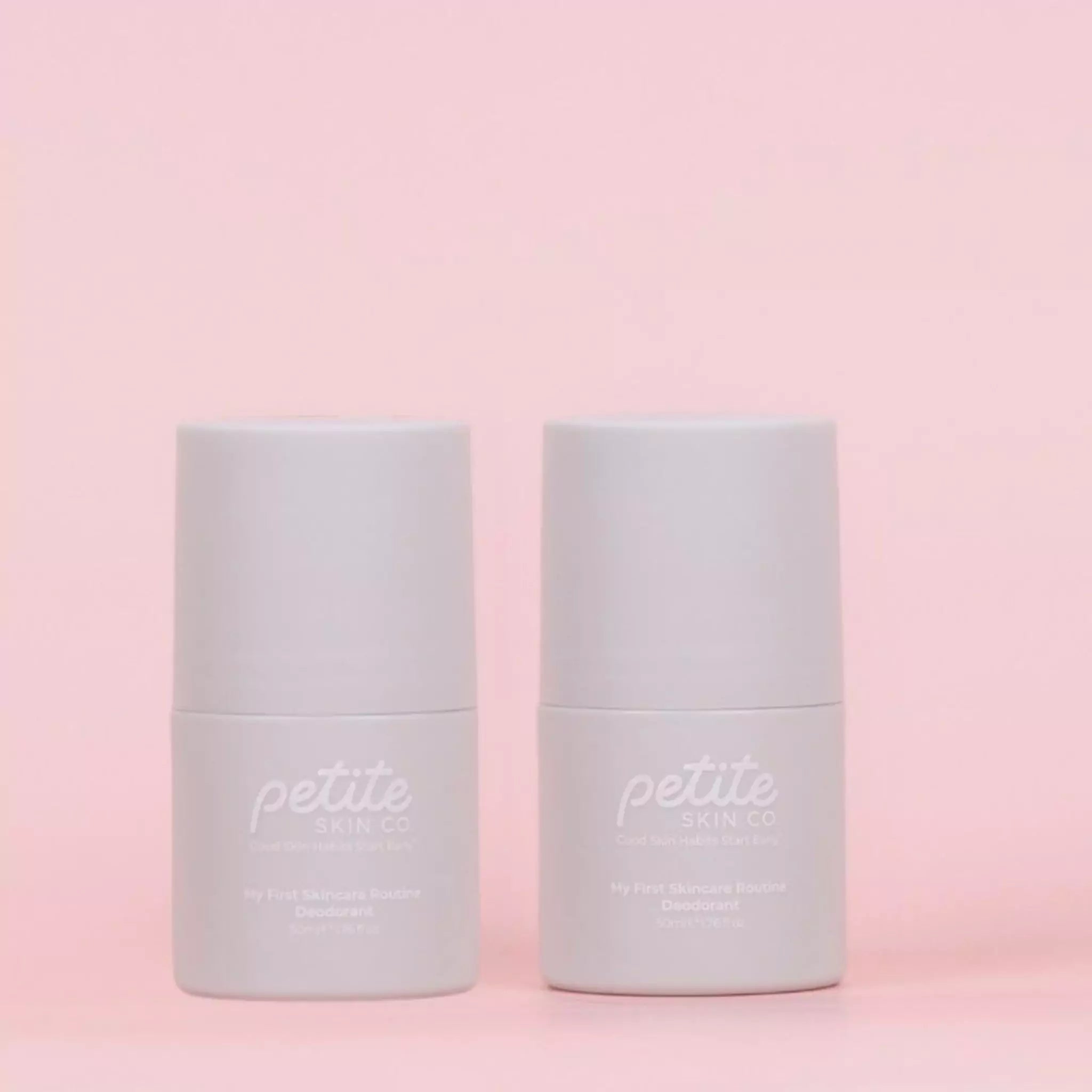 Two petite skin co. crisp evergreen roll on deodorants on a pastel pink background.