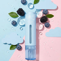 Clear and Balanced Duo blemish serum bottle surrounded by blueberries, blackberries, green leaves, and water droplets on a pastel pink and blue background, Australian made natural skincare for 7 to 14 year olds, good skin habits start early.