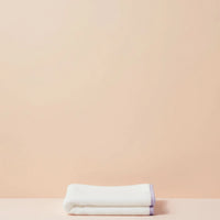 Folded white towel on a beige background