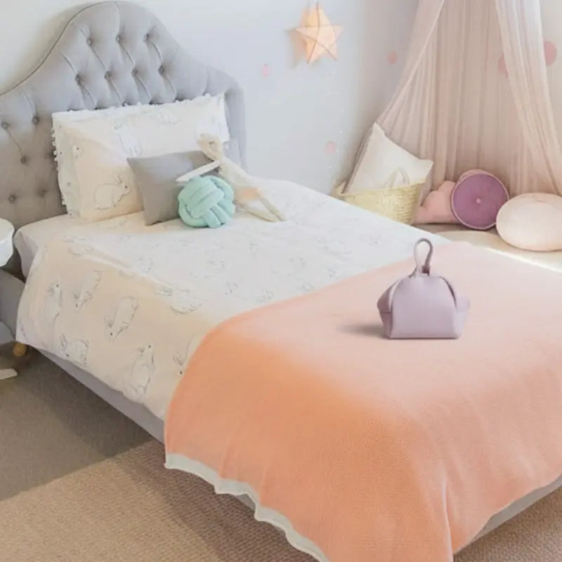 The Lilac Cloud Bag placed on a neatly made child’s bed with soft pastel bedding in a cozy bedroom, Australian made, natural, designed for the biology of 7 to 14 year old skin. Good Skin Habits Start Early.