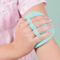 Child using a mint-colored Body Buffer with soft silicone bristles on their arm, designed for gentle Australian made skincare for 7 to 14 year olds. Good Skin Habits Start Early.