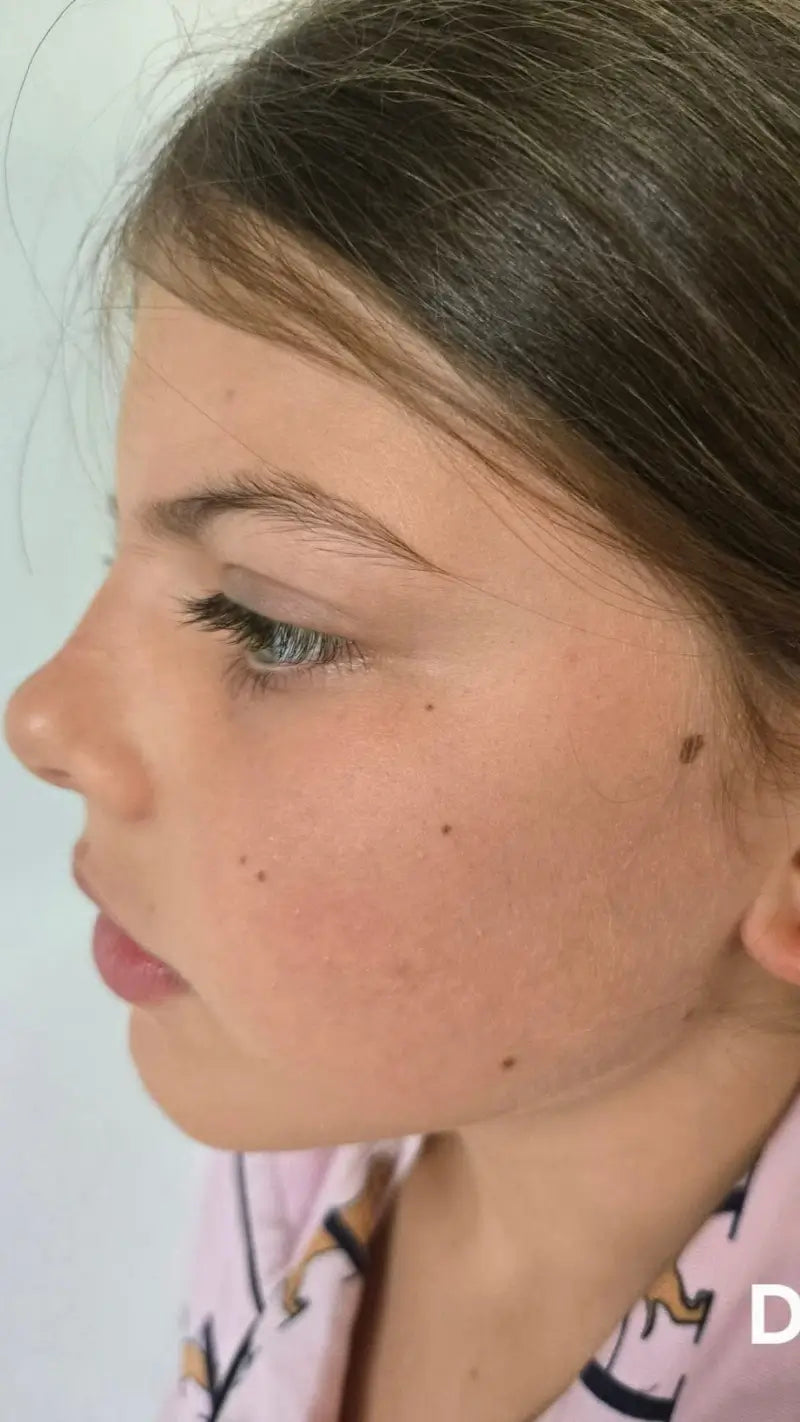 Close-up of a person's face with a neutral expression on a white background