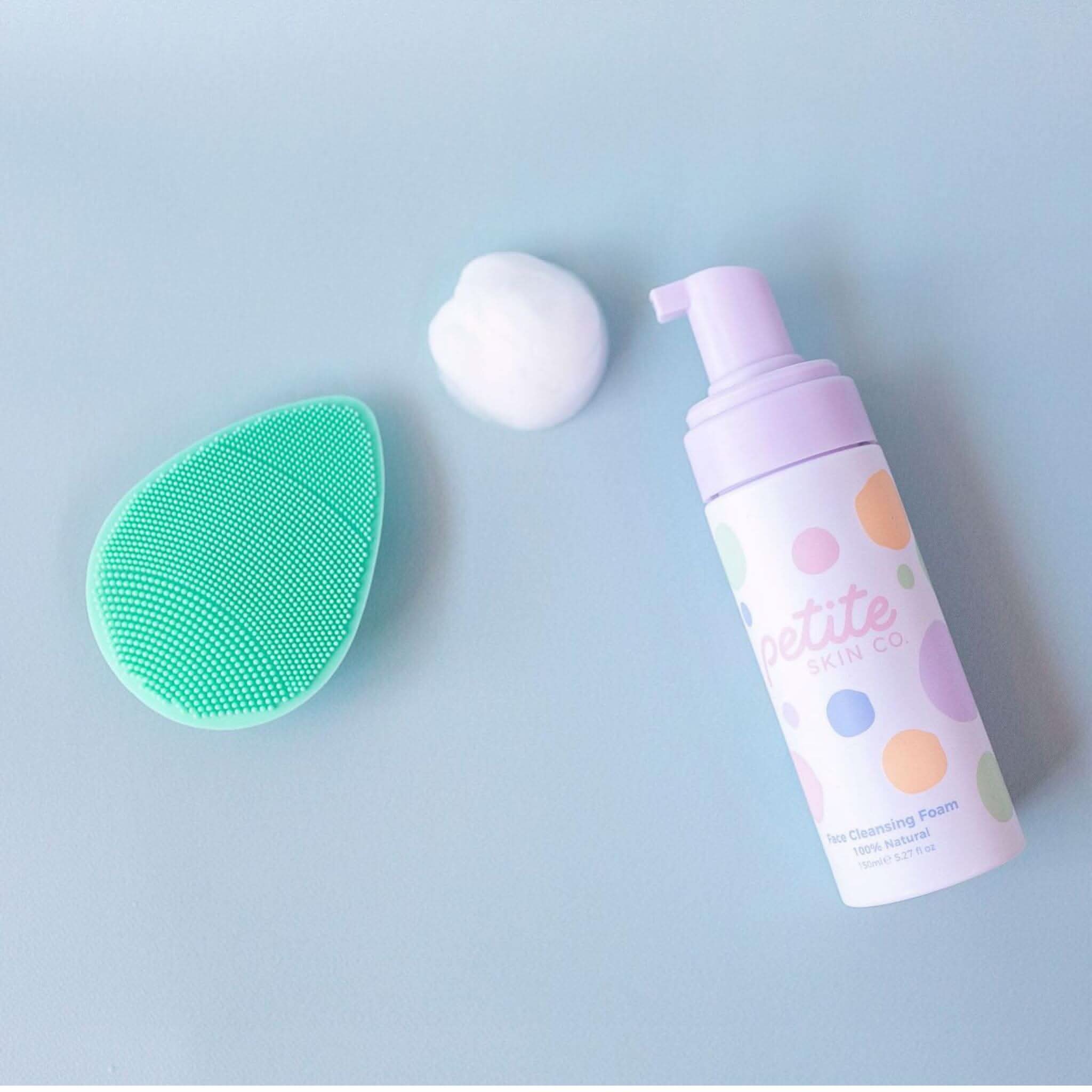 flat lay image face cleanser, buffer and foam on blue background