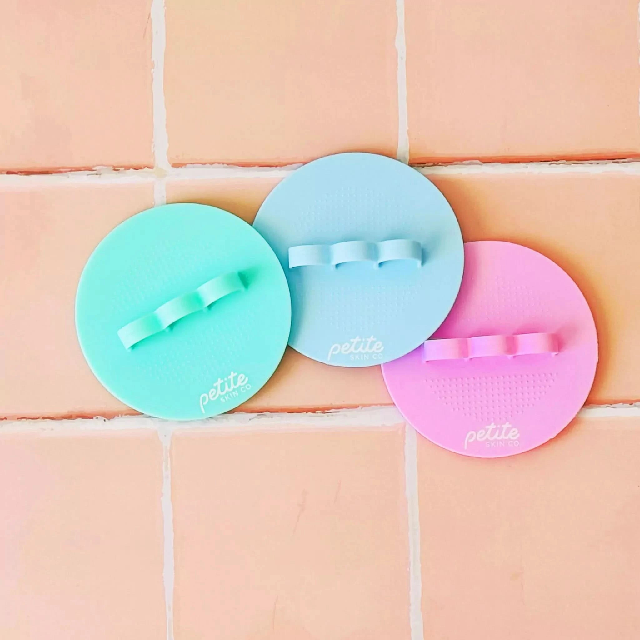 Three Australian made Body Buffer silicone cleansing pads in pastel pink, mint, and blue designed for gentle skincare for 7 to 14 year olds with soft bristles and easy grip. Good Skin Habits Start Early.