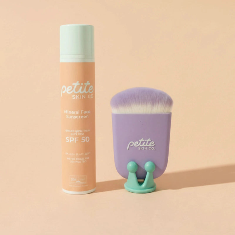 Petite Skin Co. sunscreen bottle and brush on a beige background