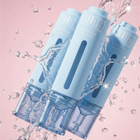 a trio of  blue petite skin co blemish serum surrounded by serum on pink background