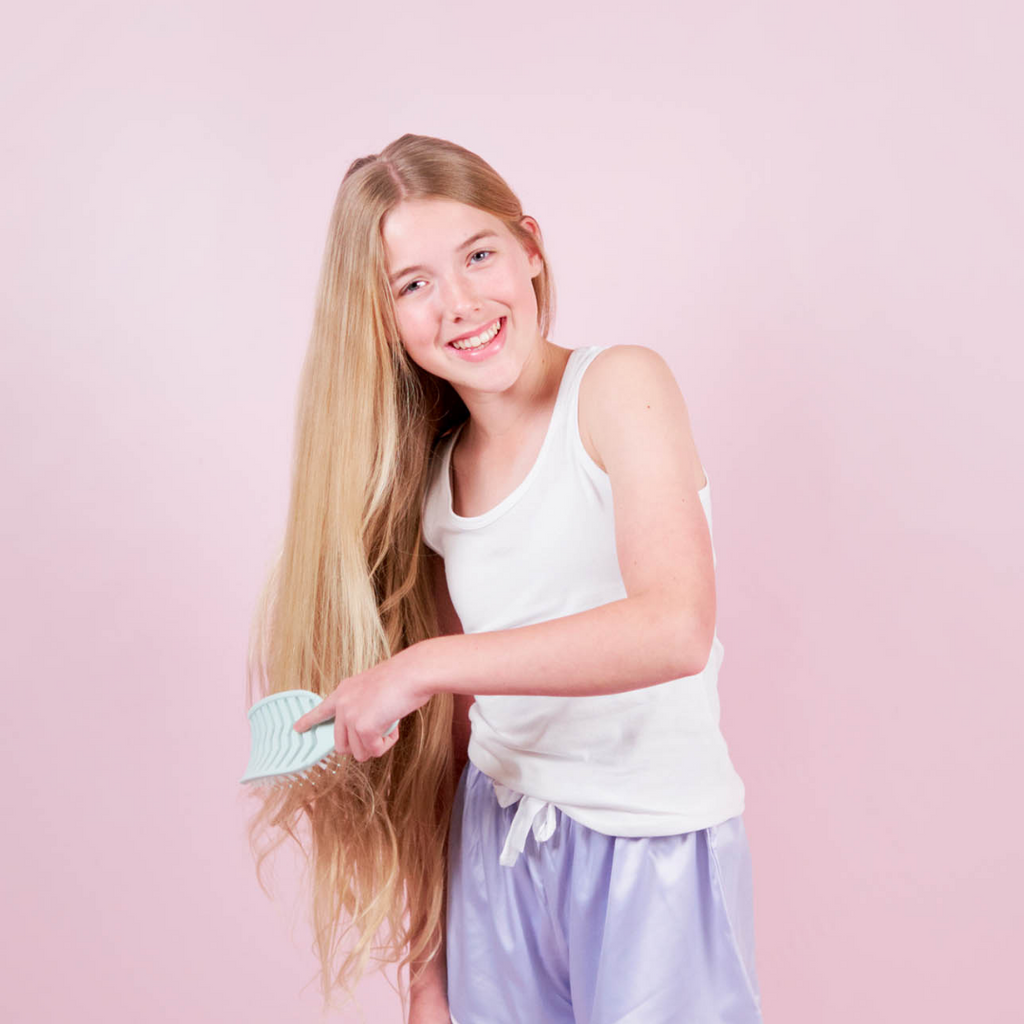 girl brushing hair with petite skin co detangling brush